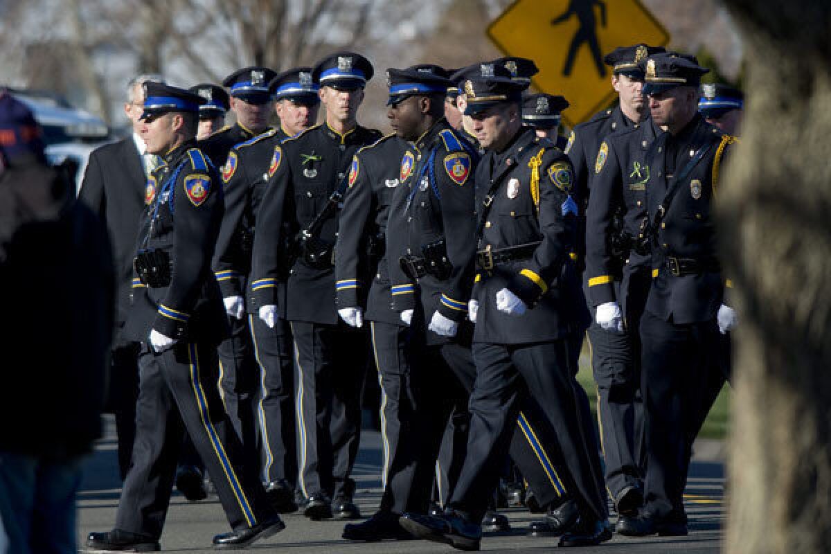 A police color guard attends the funeral for Sandy Hook Elementary School teacher Victoria Soto. The Milwaukee County Sheriff has advocated putting an armed officer in every school.