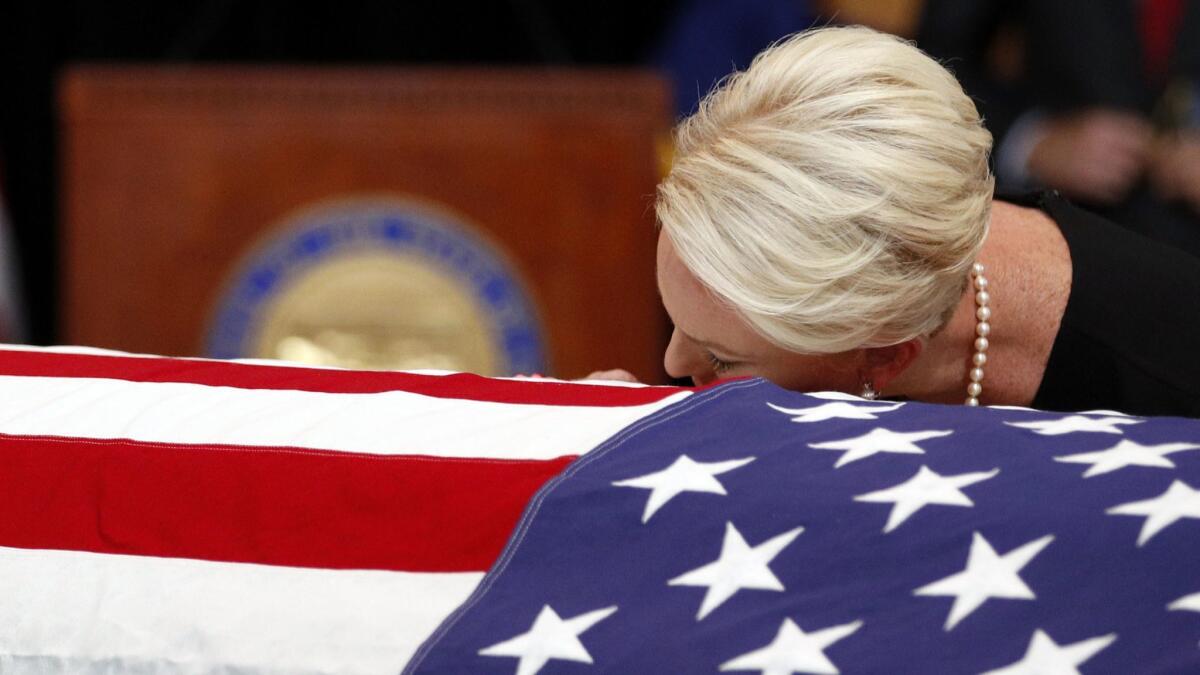 Cindy McCain, wife of Sen. John McCain, lays her head on his casket during a memorial service at the Arizona Capitol on Wednesday.