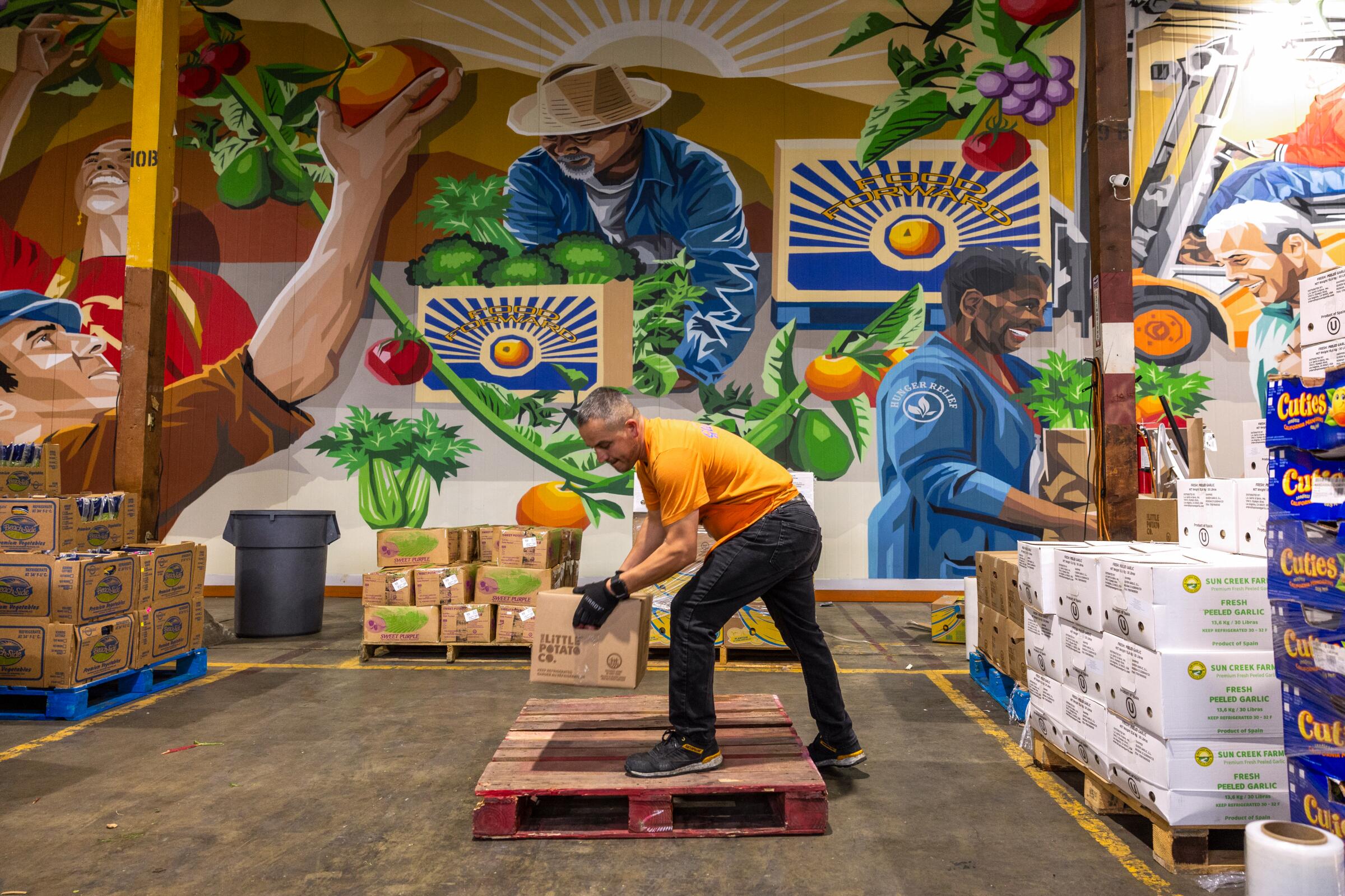Jorge Santa Cruz prepares a pallet of produce for pickup