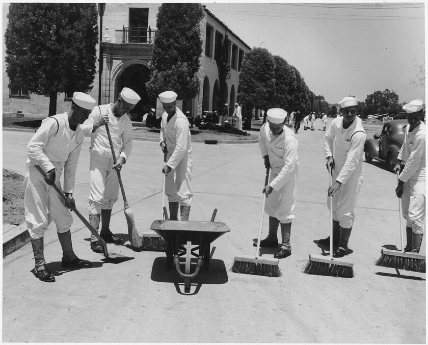 Sailors sweep the road in front of Barracks 19 in its early days as part of the Naval Training Center in Point Loma. 