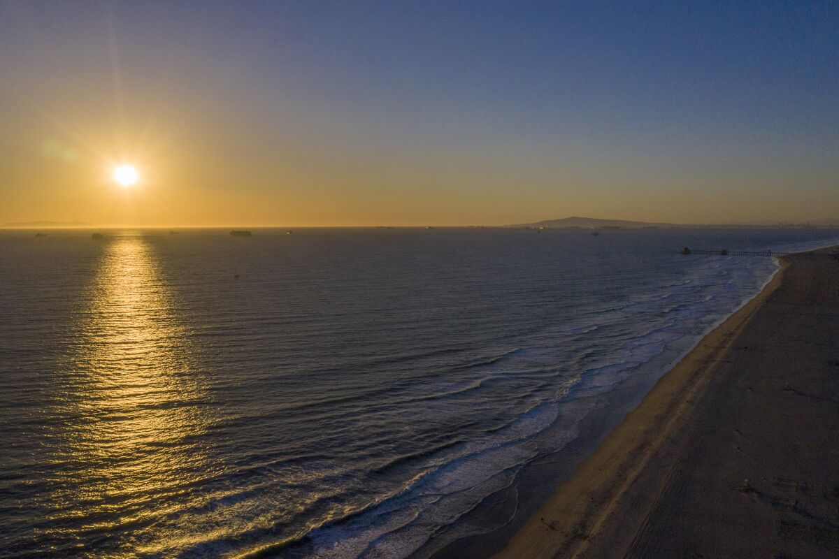 The sun sets over the ocean off the coast of Huntington Beach.