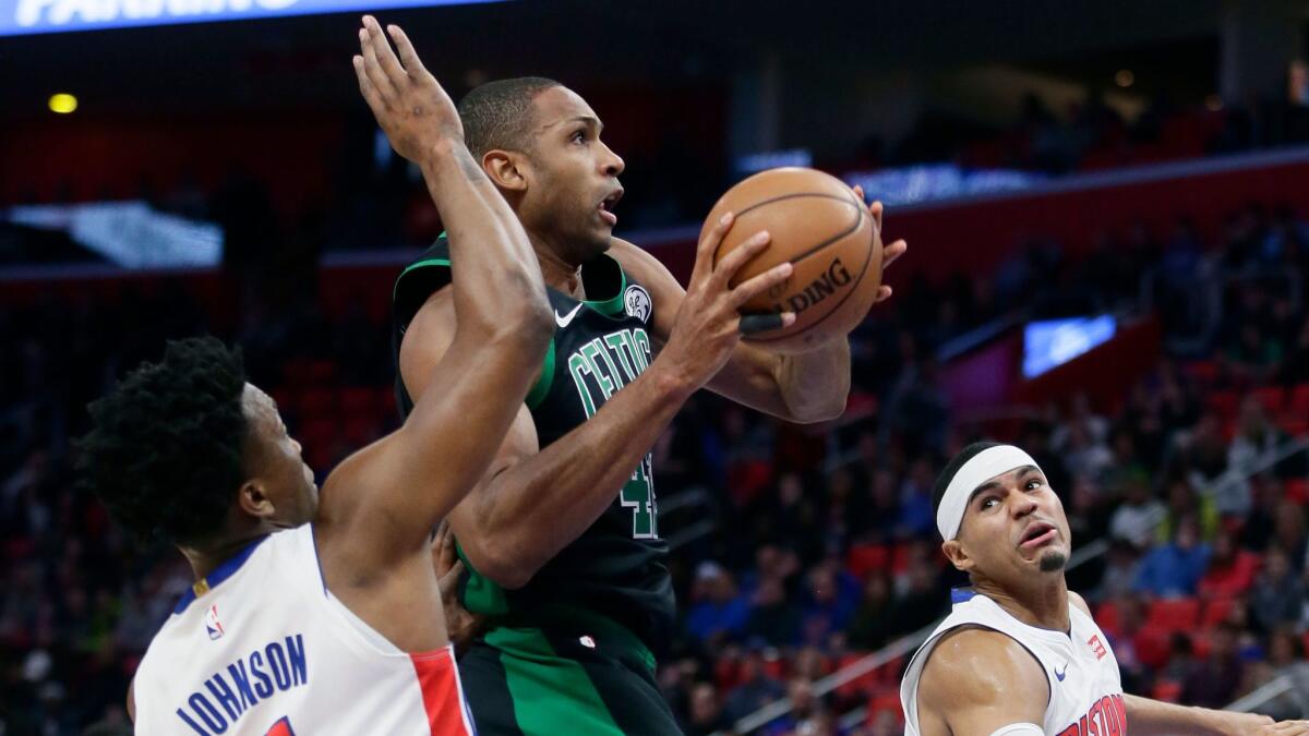 Boston Celtics forward Al Horford goes to the basket against Detroit Pistons forwards Stanley Johnson and Tobias Harris during the first half.