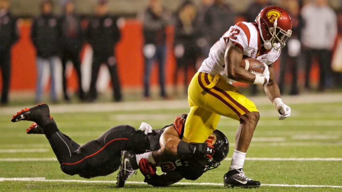 USC running back Justin Davis is tackled by Utah linebacker Sunia Tauteoli during the Trojans' 31-27 loss on Saturday.