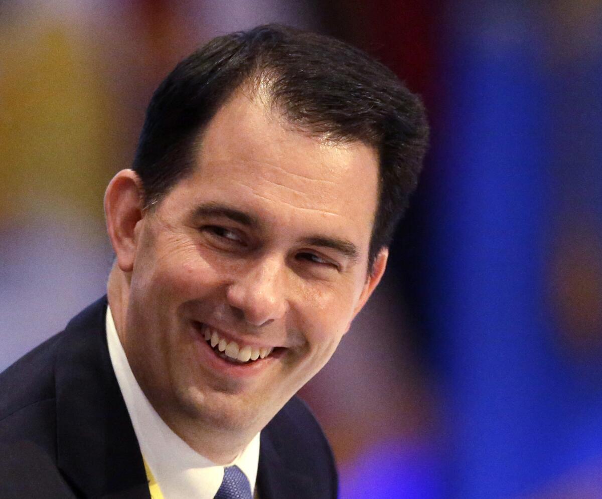 Why is this man smiling? Wisconsin Gov. Scott Walker.