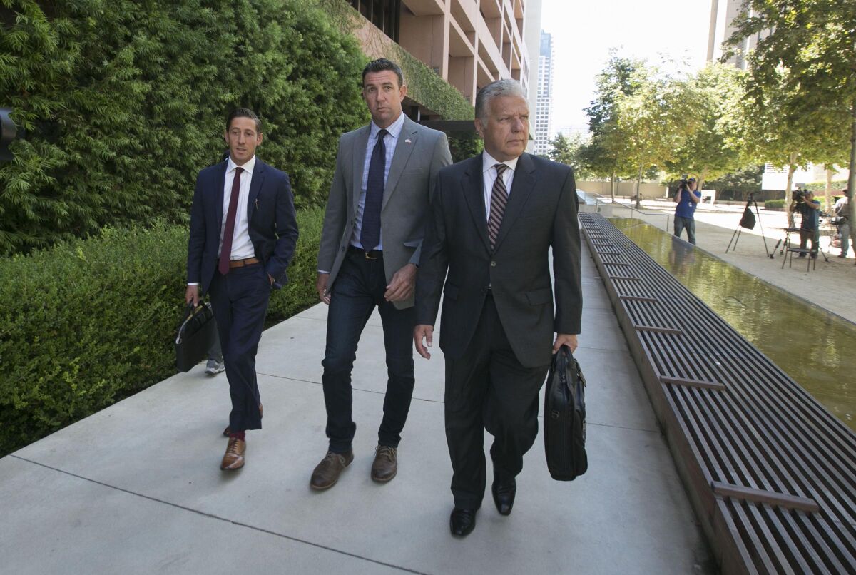 Rep. Duncan Hunter, center, and two of his attorneys, Devin Burstein, left, and Gregory Vega, right, exited federal court in San Diego in August, where he was granted a delay in his campaign finance corruption trial until January, pending an appeal of an earlier ruling.