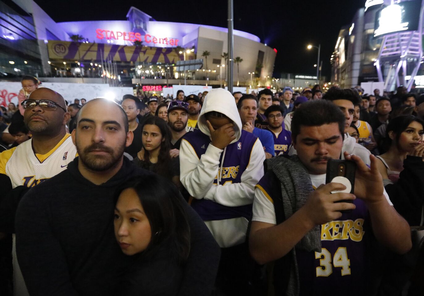 Fans outside Staples Center are overcome with emotion while watching a pregame tribute to Lakers legend Kobe Bryant on Jan. 31, 2020.