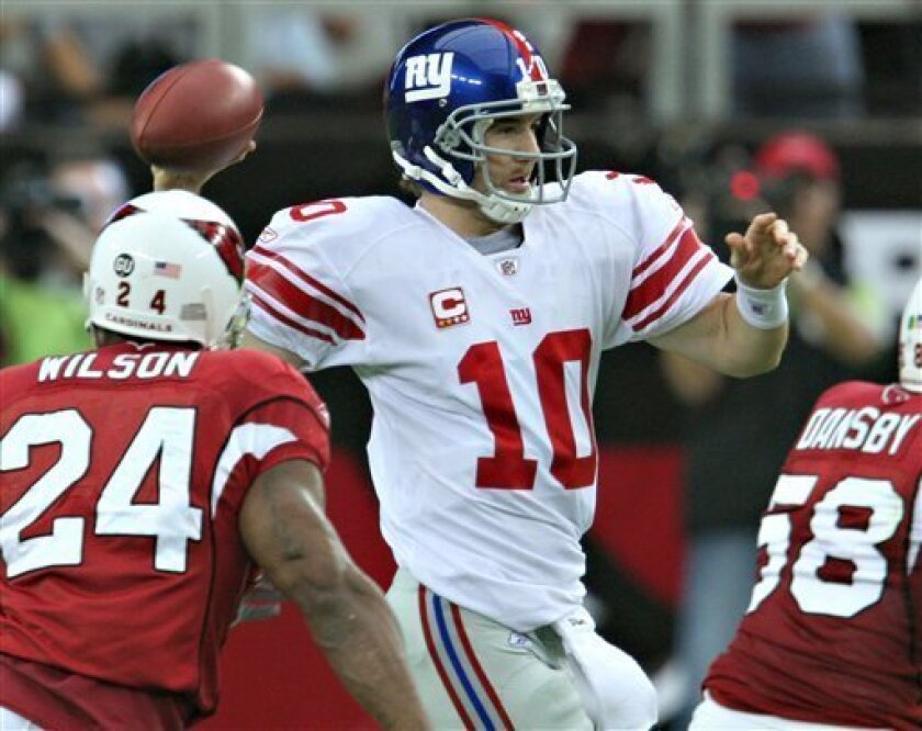 New York Giants quarterback Eli Manning (10) throws as Arizona Cardinals Adrian Wilson (24) and Karlos Dansby (58) defend during the first quarter of an NFL football game Sunday, Nov. 23, 2008 in Glendale, Ariz. (AP Photo/Ross D. Franklin)