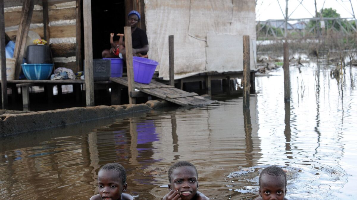 Children swim in front of a flooded house in Yenagoa, Nigeria on Nov. 15, 2012.