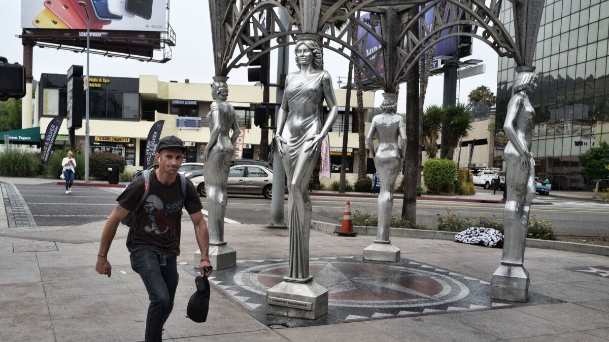 A skateboarder rides past the "Four Ladies of Hollywood" gazebo on Hollywood Boulevard on June 19.