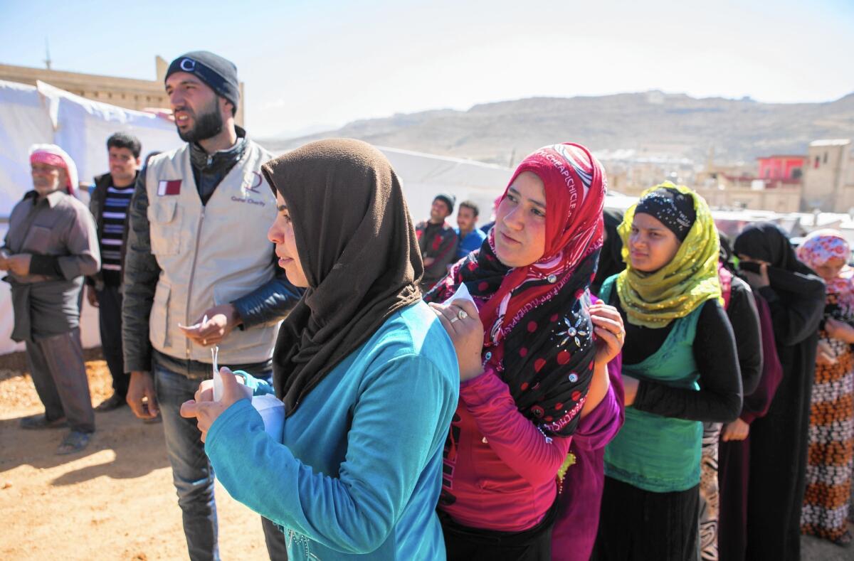 Syrian refugees wait for food parcels at a camp near Arsal, Lebanon, on Oct. 25. The United States has taken in only 300 of the more than 3.2 million refugees fleeing the Syrian civil war.