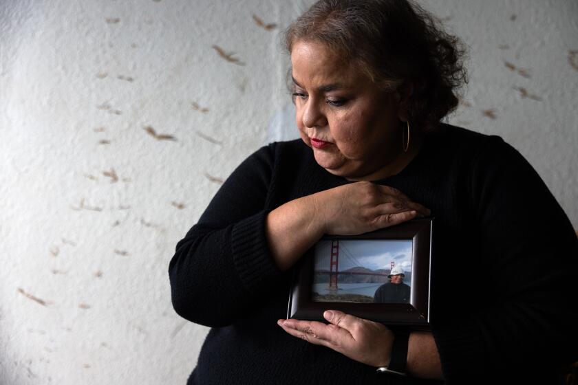 Los Angeles, CA - July 13: Portrait of Sandra Munoz, a celebrated civil rights attorney in Los Angeles. She is holding a photo of her husband Luis on January 3, 2024, in Los Angeles, CA. They have been separated since 2015. Luis, who was undocumented, applied for a waiver of his illegal entry to seek citizenship after they got married. The final step was considered a formality -- he would go back to El Salvador for an interview at the U.S. consulate there and fly back to the U.S. once it was approved. Instead, it was denied. When their lawyers pressed the government for why, the State Department admitted that his tattoos -- of La Virgen de Guadalupe, a tribal design and theatrical masks -- were among the reasons they had found him to be an MS-13 gang member, an assertion he vehemently denies. Last year, the 9th Circuit sided with the couple, but the Biden administration appealed to the Supreme Court. The high court is expected to decide next month whether to take up the case, which would have ripple effects for any immigrant seeking to challenge the government's views of their character. (Francine Orr / Los Angeles Times)