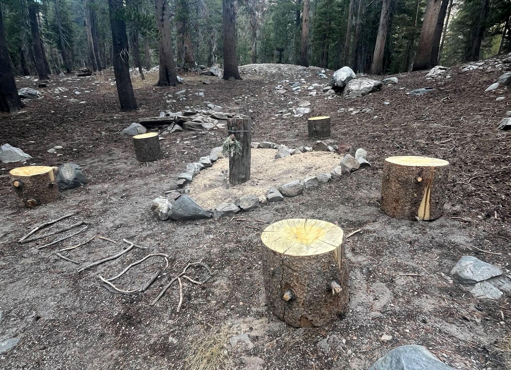 A memorial for Victor the bear featuring stone rocks formed into a heart and his name spelled in twigs.