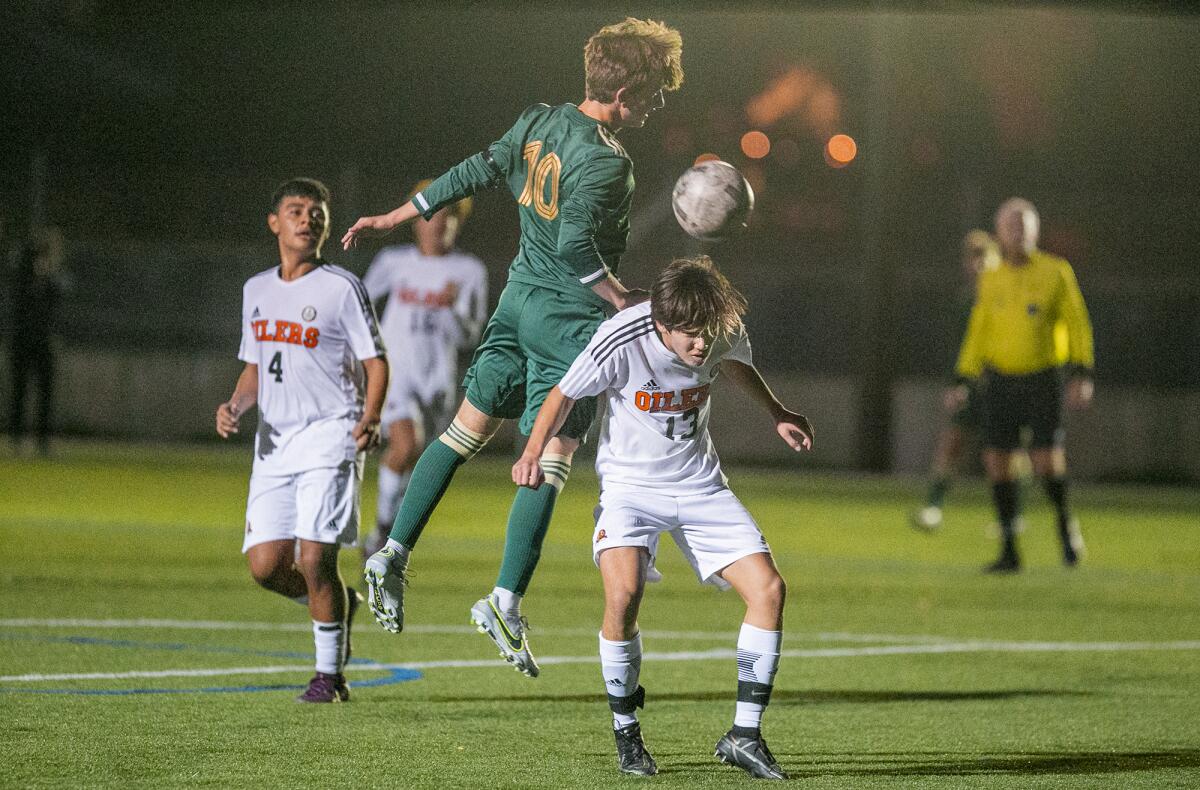 Edison's Dane Peterson and Huntington Beach's Dillon Kosai go up for a header during a Surf League match on Wednesday.