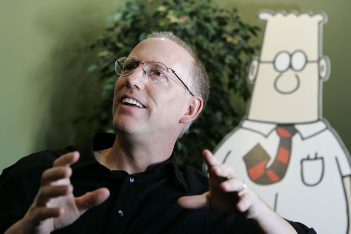 Cartoonist Scott Adams with paper cutout of Dilbert behind him