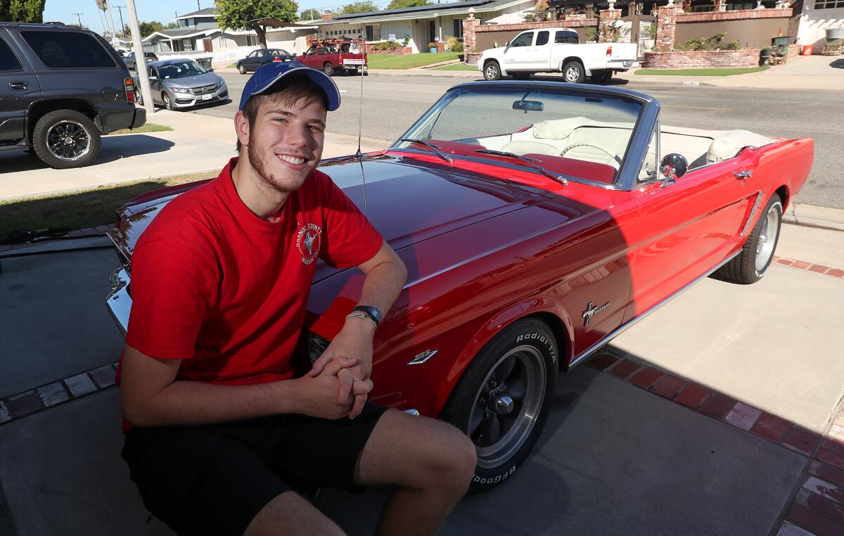 Daniel Morgan with a 1965 Mustang 298 his grandpa restored in 1983 as a gift for Morgan's aunt Beverly. 