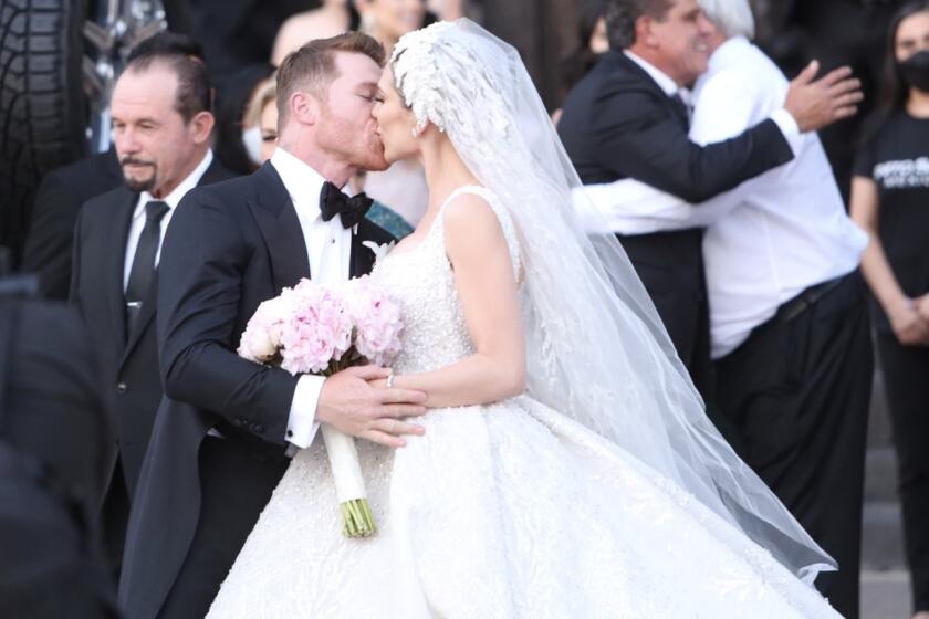 El Canelo sella su unión con un beso a su esposa Fernanda Gómez frente a su público.