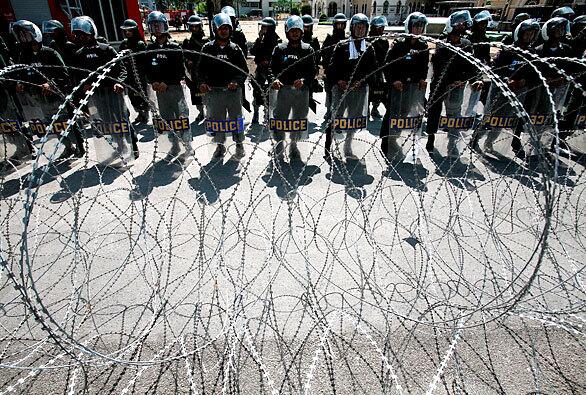 Riot police stand guard outside Government House during an anti-government protest in Bangkok, Thailand. Thousands of demonstrators who support deposed populist Prime Minister Thaksin Shinawatra are demanding the dissolution of parliament and fresh elections.