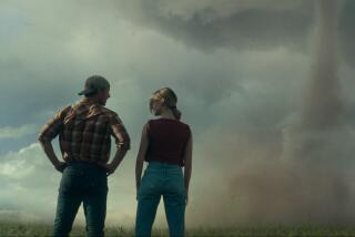 Two colleagues discuss the giant tornado in front of them.