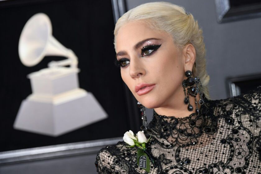 Lady Gaga posing in a lace dress and dark eye makeup