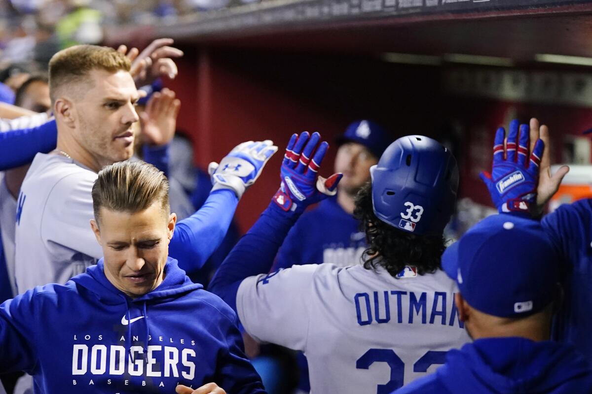 James Outman (33) celebrates with Freddie Freeman, left, and his Dodgers teammates after hitting a solo home run.