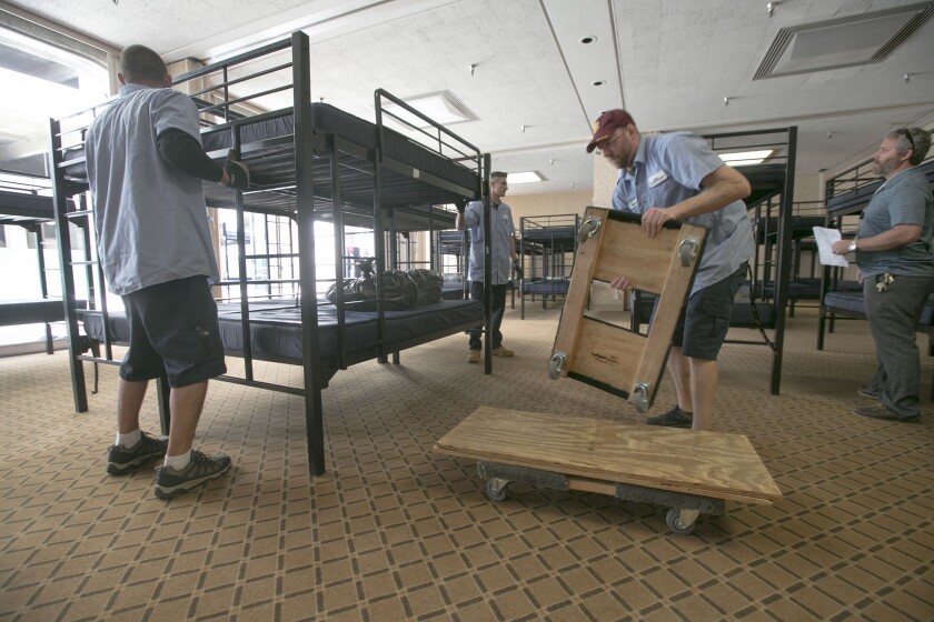 Movers from CNM Relocation Services move bunk beds in to Golden Hall, where a temporary bridge shelter was being set up in April to house homeless families.