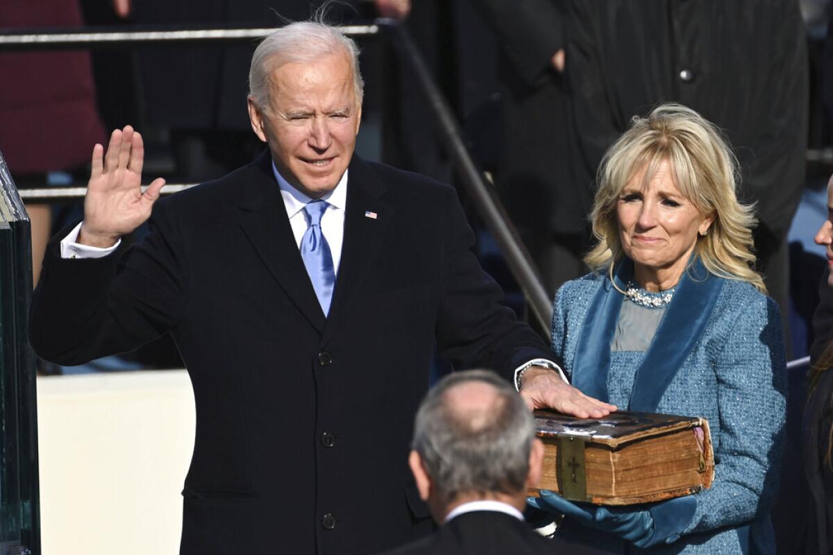 The U.S. Capitol and stage are lit as the sun begins to rise before events get underway for Joe Biden's inauguration.