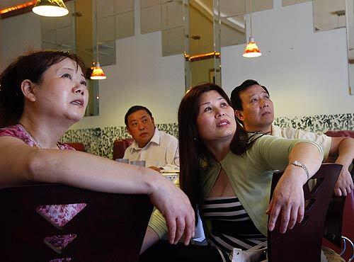 From left, Tang Xiulan, Zhou De Zhao, Liang Pinghong and Xie Cheng watch coverage of the earthquake on a Chinese news channel during lunch at Chung King Restaurant, a famed Sichuan eatery in the heart of San Gabriel Valley's sizable Chinese community. Observers say Sichuanese immigrants began flowing into the area in the 1990s, many seeking jobs in restaurants or the import-export industry.