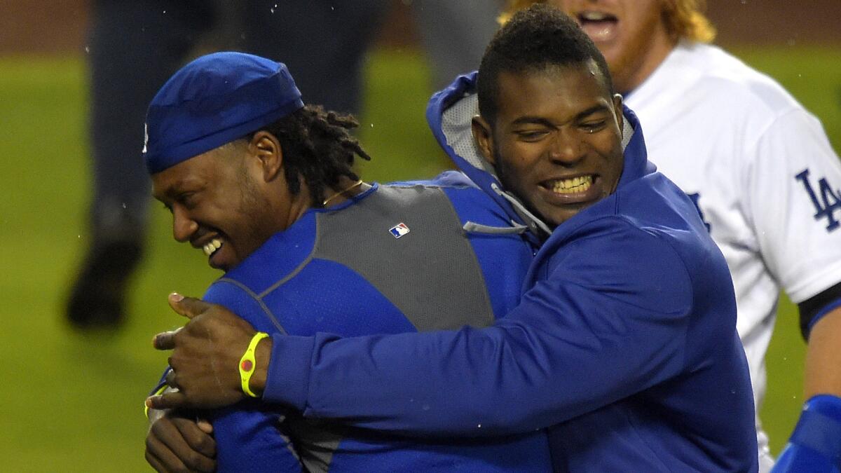 Dodgers shortstop Hanley Ramirez, left, is hugged by teammate Yasiel Puig after hitting a walk-off home run during the 12th inning of the team's 5-2 win over the Chicago Cubs on Saturday.