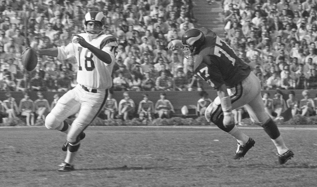 Rams quarterback Roman Gabriel, left, looks to pass against the Minnesota Vikings.