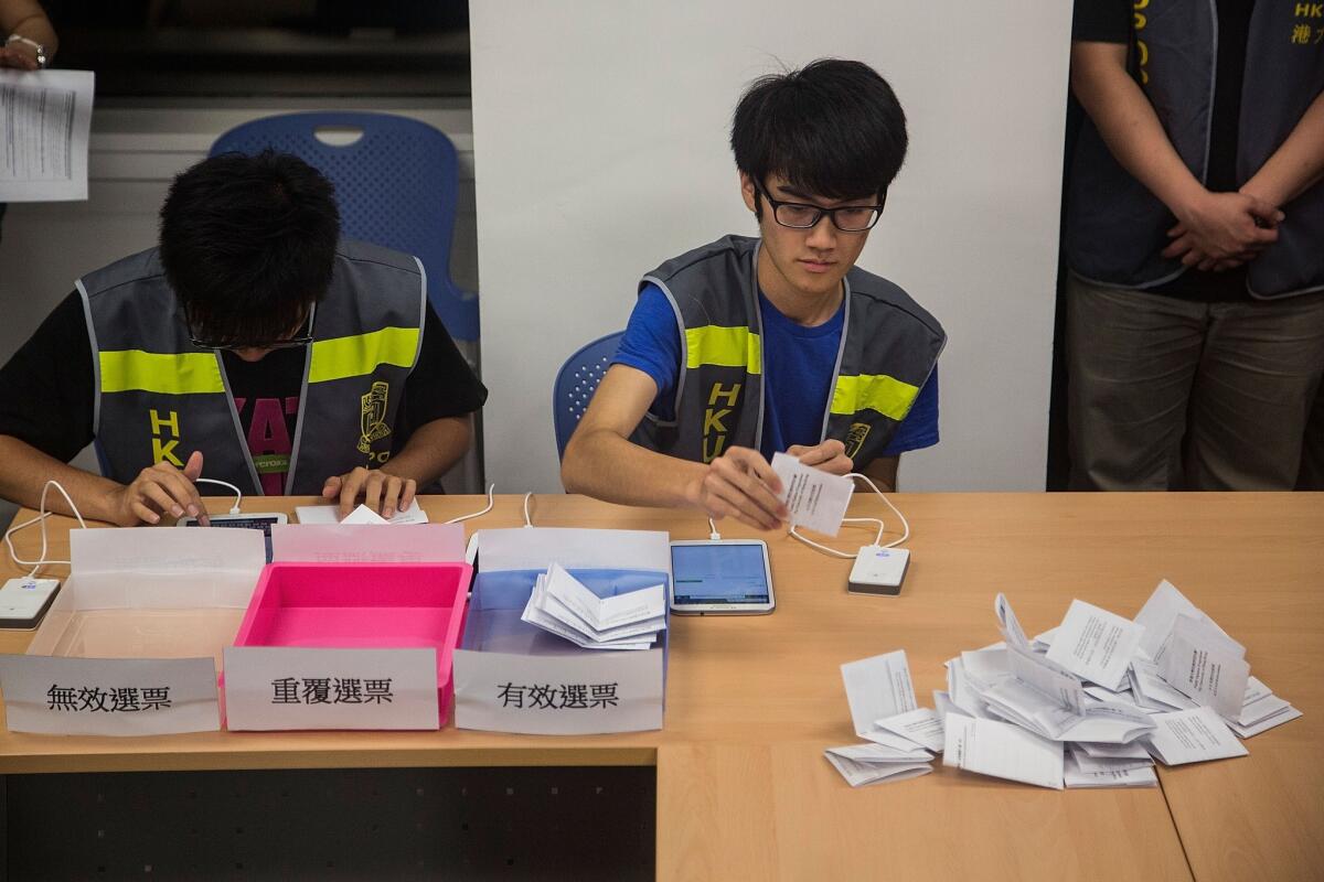 Ballot counting officers get to work in Hong Kong on Sunday after a 10-day pro-democracy vote was conducted online, via mobile phones and in person.