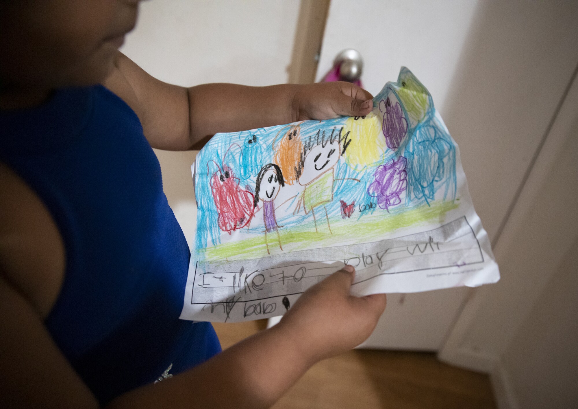 Jennifer, 6, shows recent drawings she did of her and her father and said "I like to play with my dad".