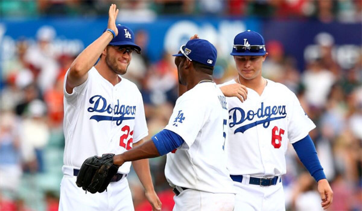 Dodgers ace Clayton Kershaw, left, celebrates with Juan Uribe, center, and Joc Pederson, right, after L.A.'s 7-5 win Sunday over the Diamondbacks in the second game of a two-game series in Australia.