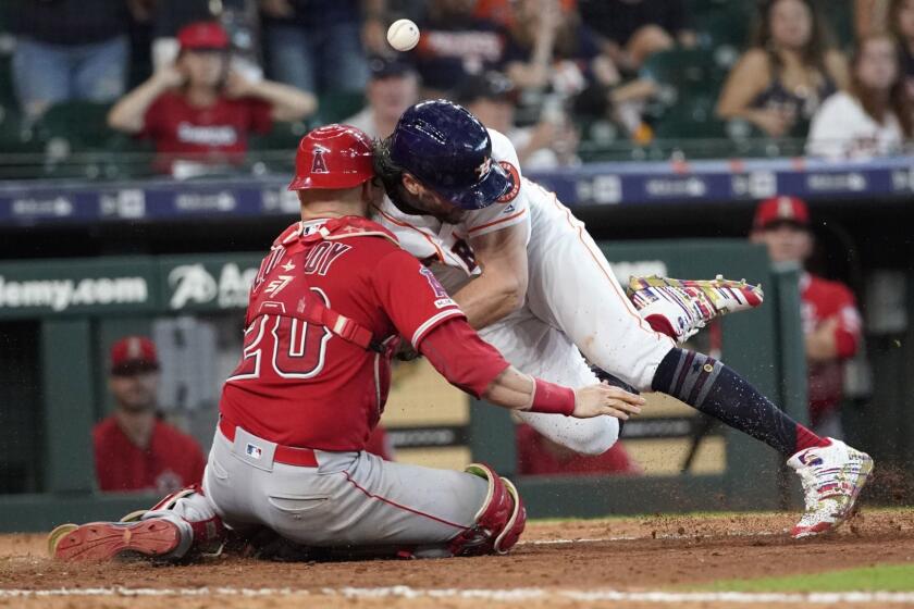 Houston Astros' Jake Marisnick, right, collides Los Angeles Angels catcher Jonathan Lucroy (20) while trying to score during the eighth inning of a baseball game Sunday, July 7, 2019, in Houston. Marisnick was called out under the home plate collision rule. (AP Photo/David J. Phillip)