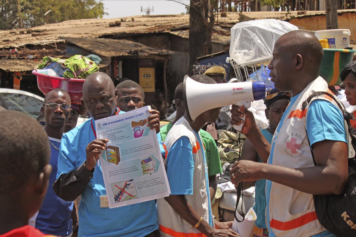 Health workers in Conakry, Guinea, teach people about the Ebola virus and how to prevent infection in March.