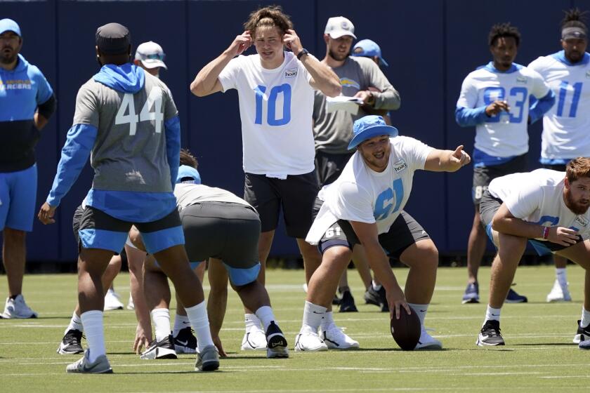 Los Angeles Chargers quarterback Justin Herbert (10) signals during the NFL football team's organized team activities.