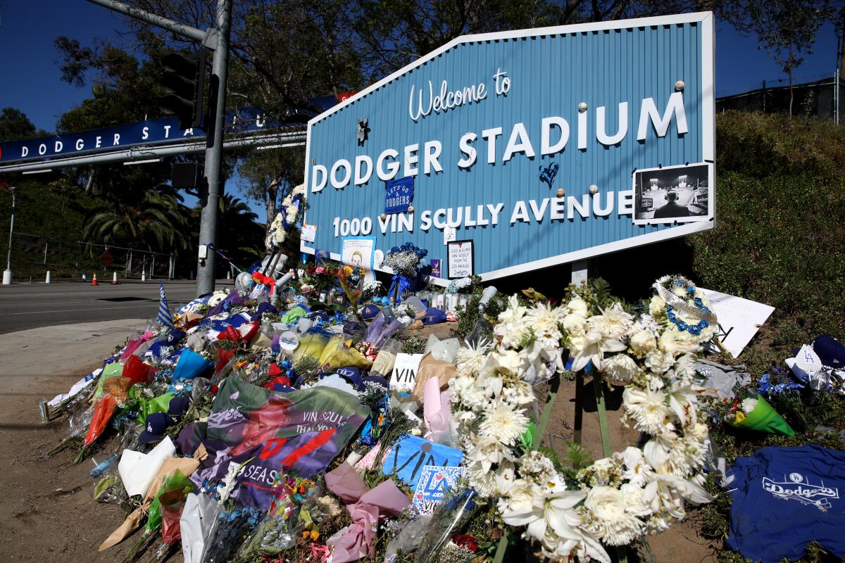 Dodgers fans pay tribute to the life of Vin Scully at the entrance of Dodger Stadium.