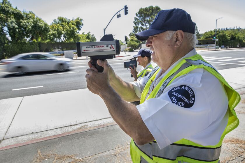 GRANADA HILLS, CA-JULY 24, 2019: Karla Hanley, 68, left, and Nishan Darakdjian, 73, use speed guns to catch motorists driving past the speed limit on Balboa Blvd. in Granada Hills. They are volunteers with the Devonshire Community Police Station in Northridge. (Mel Melcon/Los Angeles Times)