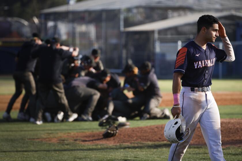 El Cajon, CA - May 30: Valhalla's Julian Jerjees (10) walks back to the dugout as Pacifica players celebrate winning the Division 4 Southern California Regional semifinal game at Valhalla High School on Thursday, May 30, 2024 in El Cajon, CA. (Meg McLaughlin / The San Diego Union-Tribune)