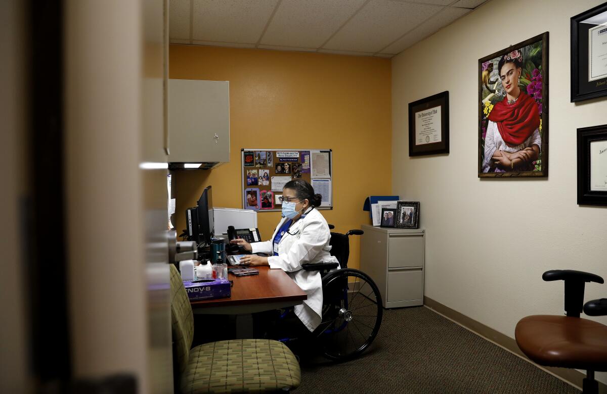 Dr. Marie Flores works at her desk at the AltaMed clinic in Pico Rivera