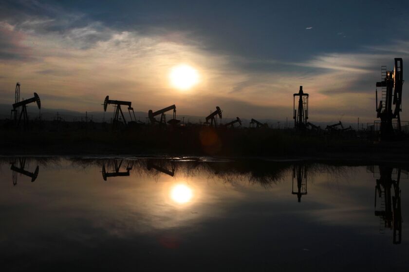 LOST HILLS, CA - MARCH 4, 2014: Oil pumps and equipment are reflected in a pool of water at the South Belridge oil field in Kern County. (Brian van der Brug / Los Angeles Times)