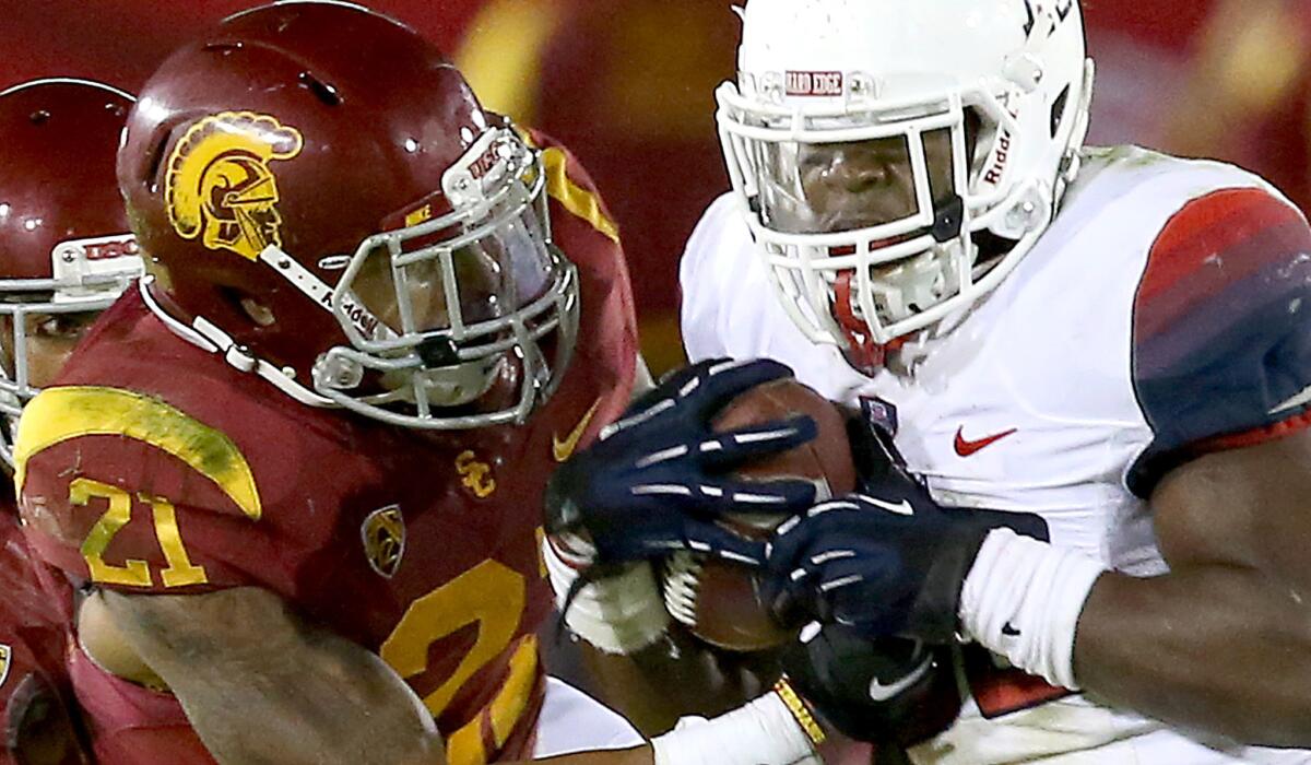USC strong safety Su'a Cravens tries to strip the ball from Arizona running back Ka'Deem Carey during a game last season.