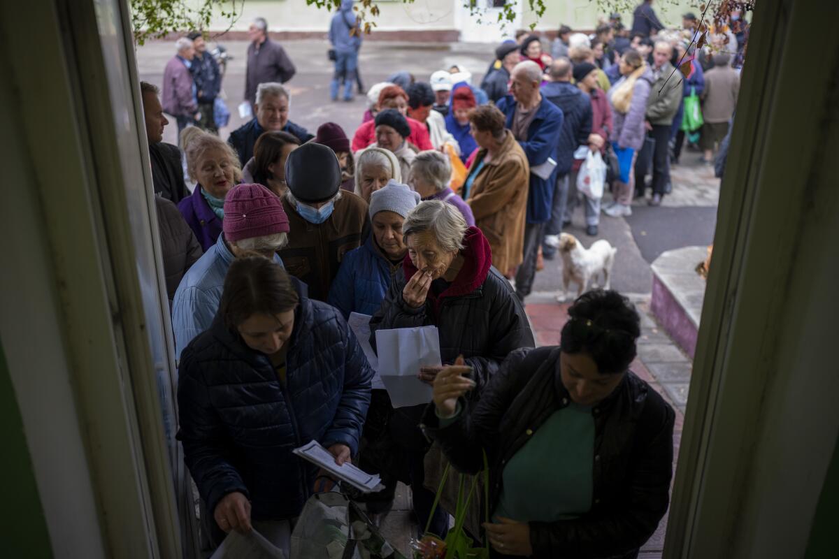 People line up to receive a daily ration of bread in a school in Mykolaiv.