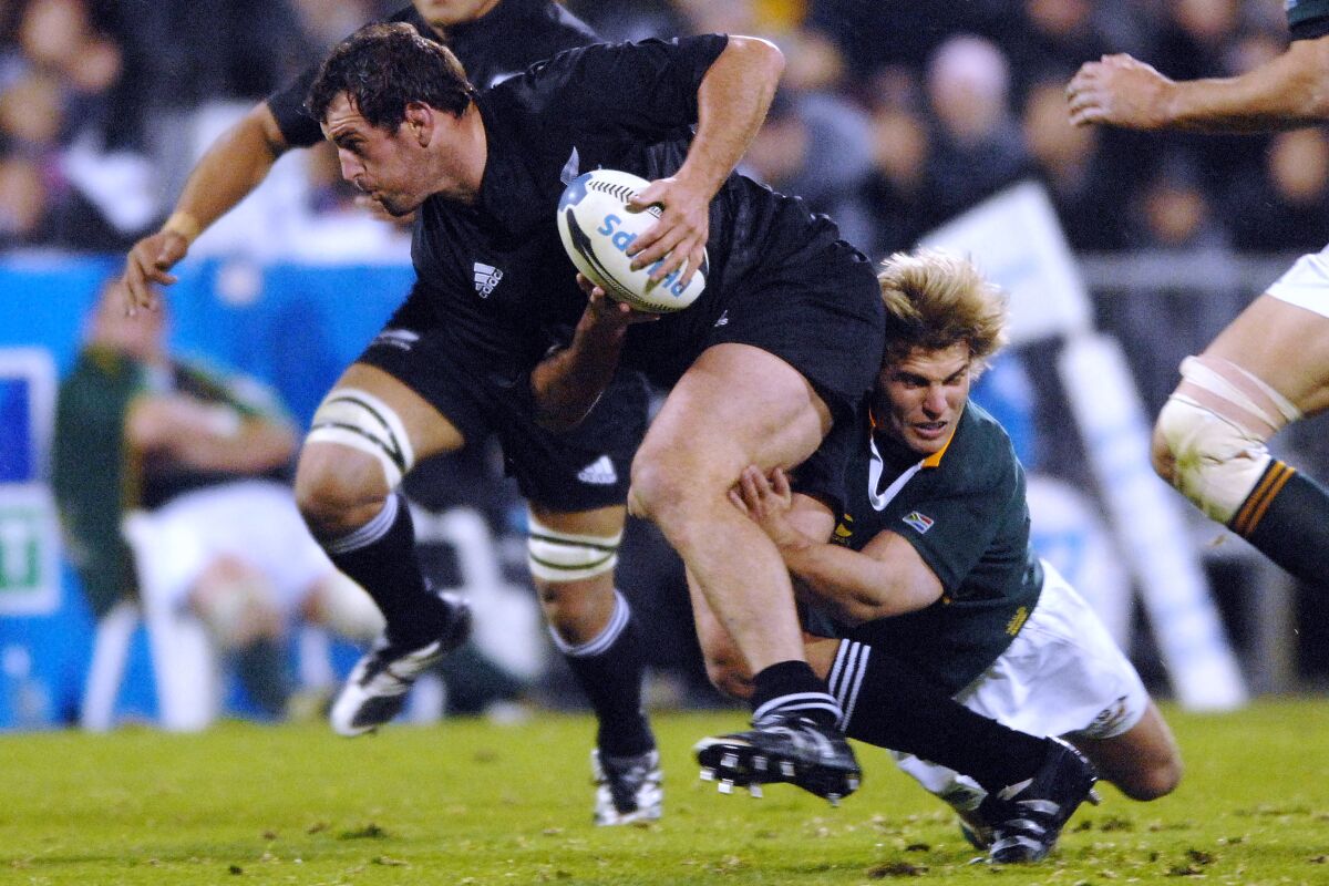 FILE - New Zealand All Blacks' Carl Hayman, left, is tackled by South African Springboks' Wynand Olivier in the international Tri Nations rugby test at Jade Stadium, in Christchurch, New Zealand on July 14, 2007. Hayman has revealed he has been diagnosed with early-onset dementia at the age of 41. (AP Photo/NZPA, Ross Setford, File)