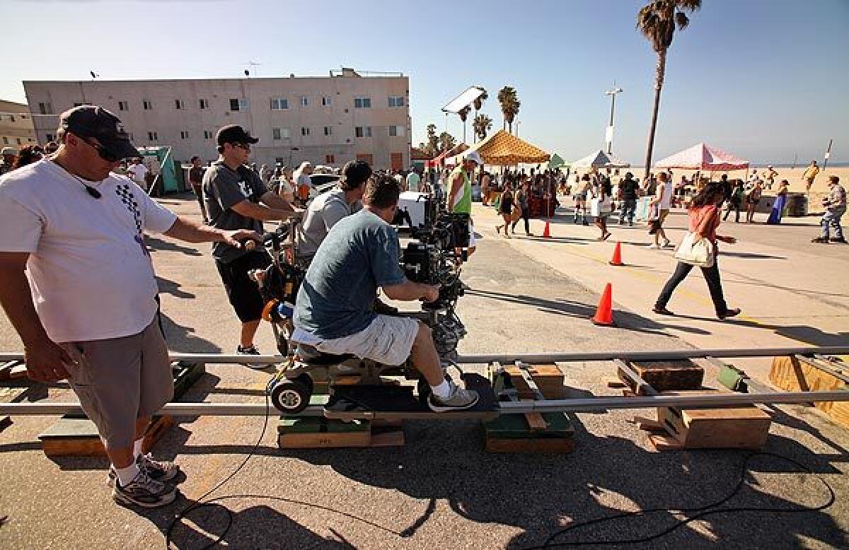 Camera operator Fred Iannone moves on a camera dolly during shooting for "NCIS: Los Angeles."