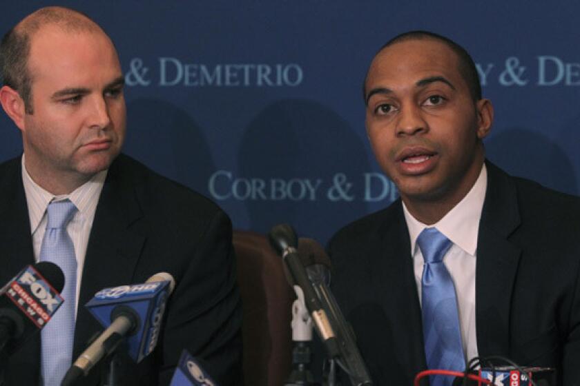 Tregg Duerson, son of former Chicago Bears player Dave Duerson, with lawyer William Gibbs, left, discusses his family's lawsuit against the NFL at law offices in 2012.