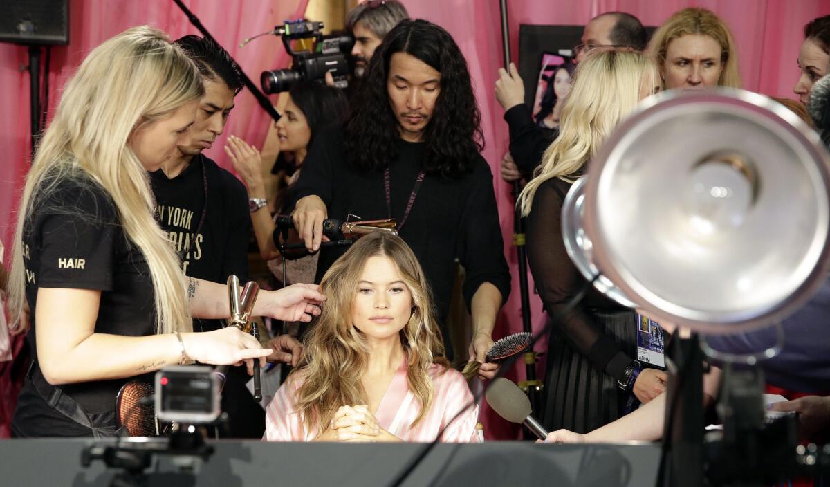 Victoria's Secret model Behati Prinsloo has her hair and makeup done backstage.