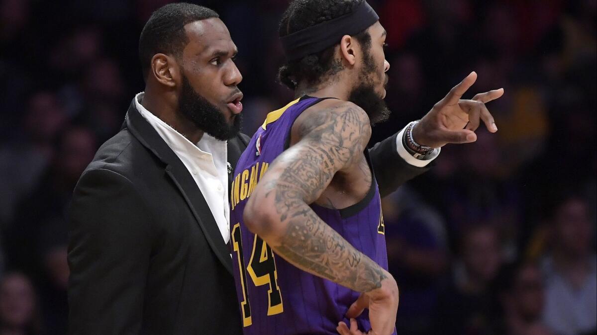 Injured forward LeBron James talks to Lakers teammate Brandon Ingram during the second half of the game against Knicks on Friday,.