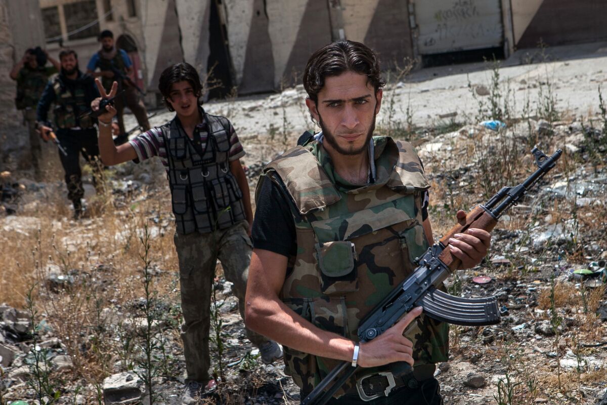 Syrian rebel fighters belonging to the "Martyrs of Maaret al-Numan" battalion leave their position after a range of shootings on June 13, 2013 in the northwestern town of Maaret al-Numan in front of the army base of Wadi Deif, down in the valley. At least 93,000 people, including over 6,500 children, have been killed in Syria's civil war, the United Nations said on June 13, 2013, warning that the true death toll could be far higher.