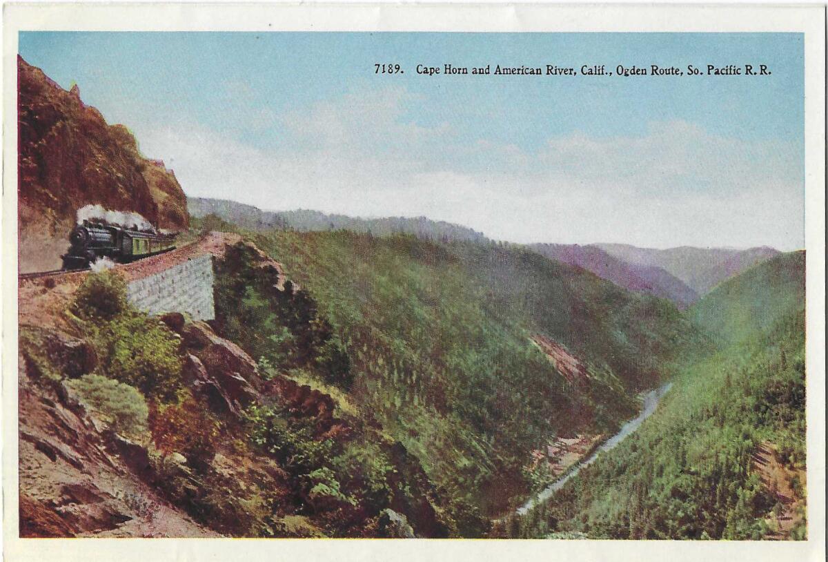 A train on a mountain pass, with a river valley below