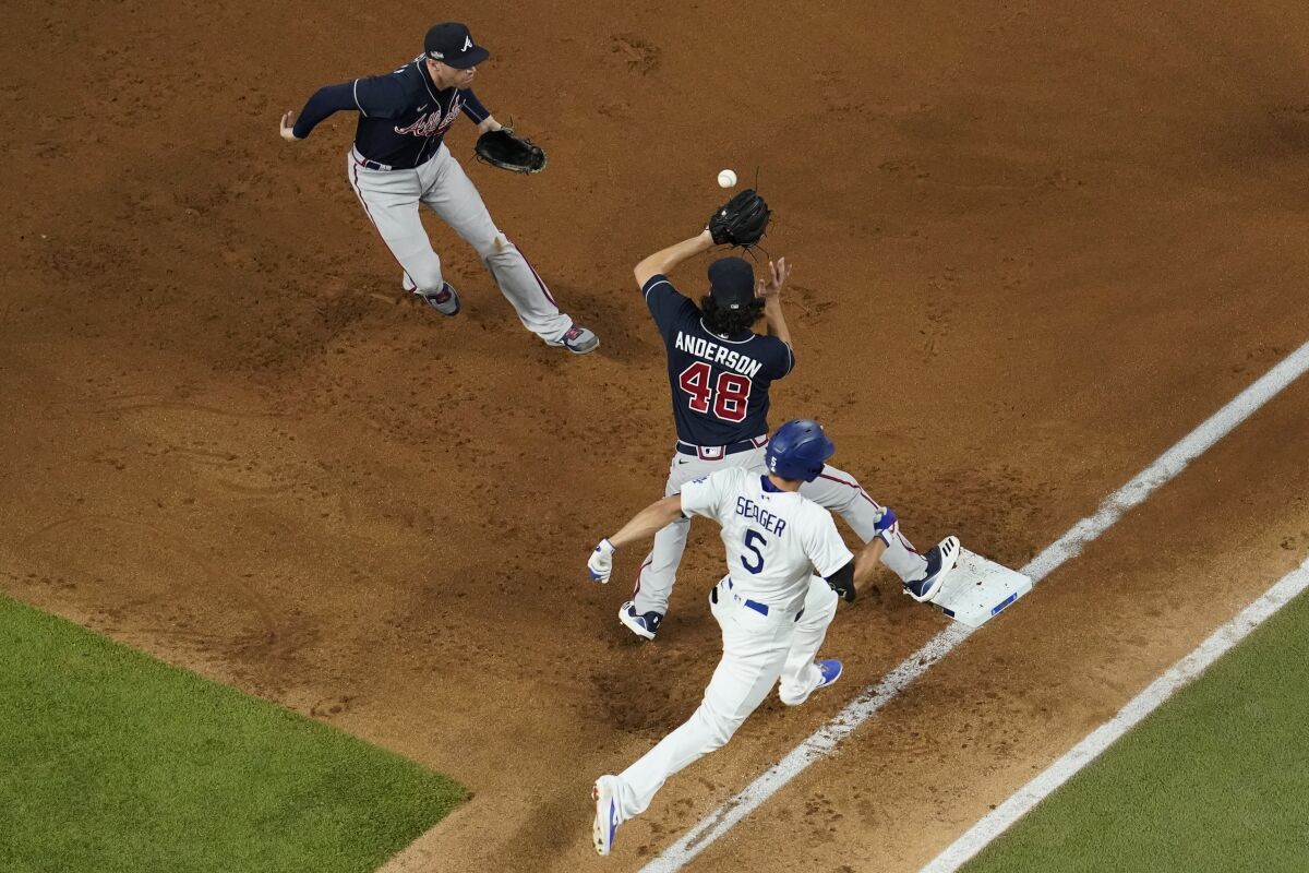 Atlanta Braves first baseman Freddie Freeman tosses the ball to Ian Anderson to force out Dodgers shortstop Corey Seager.